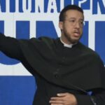 Calvin Robinson raising his arm in the air during a speech at the National Pro-Life Summit in Washington, DC.